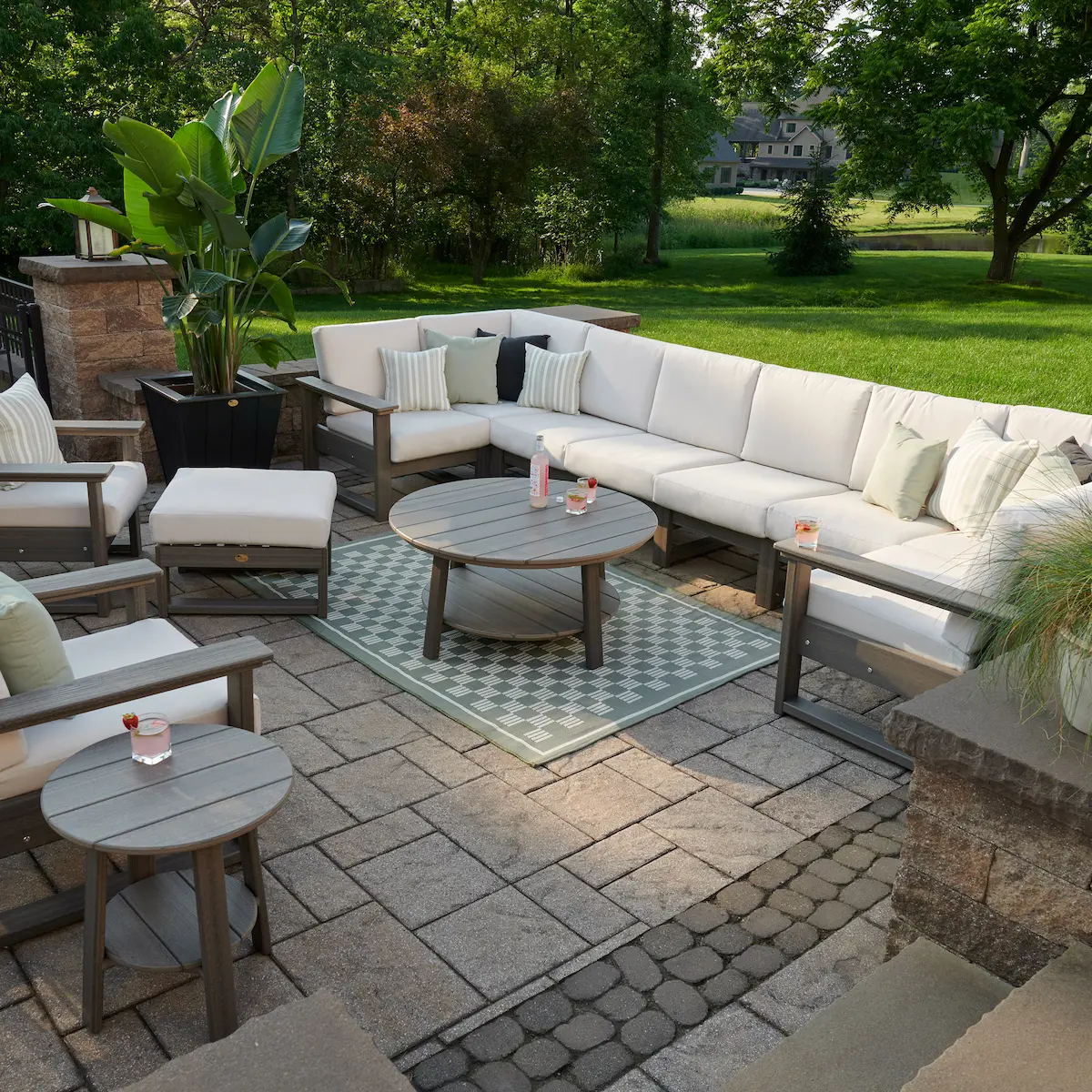 Amish made outdoor patio design with custom sectional seating, stone paver patio, and coordinating coffee table, showcasing American made craftsmanship and a cohesive custom outdoor living space ideal for entertaining.